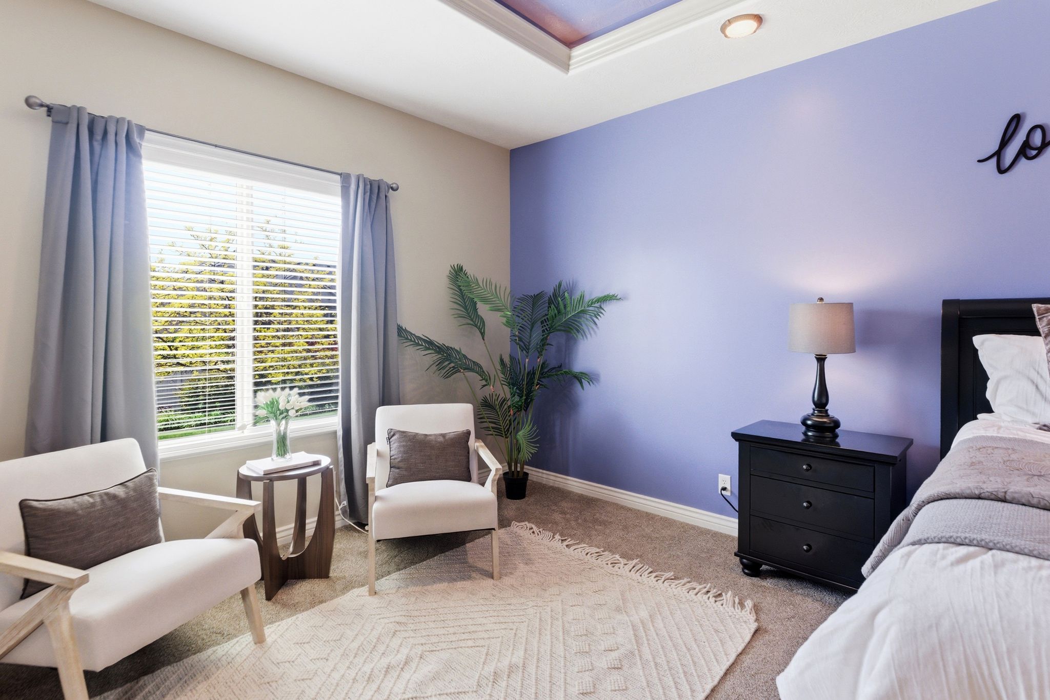 Spacious room featuring a large window with blinds, tray ceiling with recessed lighting, and soft carpet flooring