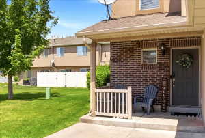 Brick facade exterior featuring a covered porch, dark entry door, and exterior lighting fixture