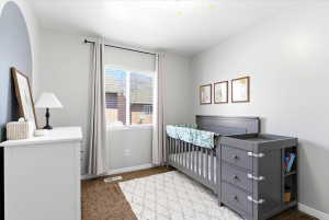Bright room featuring a single window with blinds and curtains, neutral wall paint, and brown carpet flooring