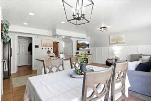 Open-concept living area featuring recessed lighting, a modern geometric chandelier, and white wainscoting