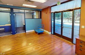 Spacious interior featuring wood-finish flooring and large glass entry doors
