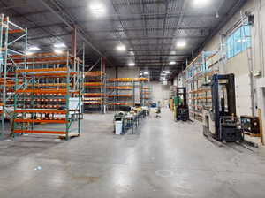 Spacious industrial warehouse featuring high ceilings and concrete flooring