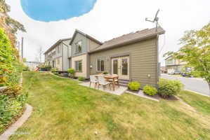 Rear exterior featuring horizontal siding in a neutral tone, double glass-paned doors, and a concrete patio