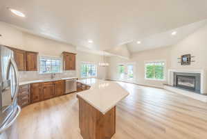 Open-concept living space featuring vaulted ceilings, light wood-finish flooring, and recessed lighting