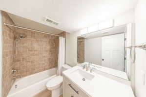 Bathroom featuring a white vanity with a rectangular sink, brushed nickel faucet, and a large frameless mirror