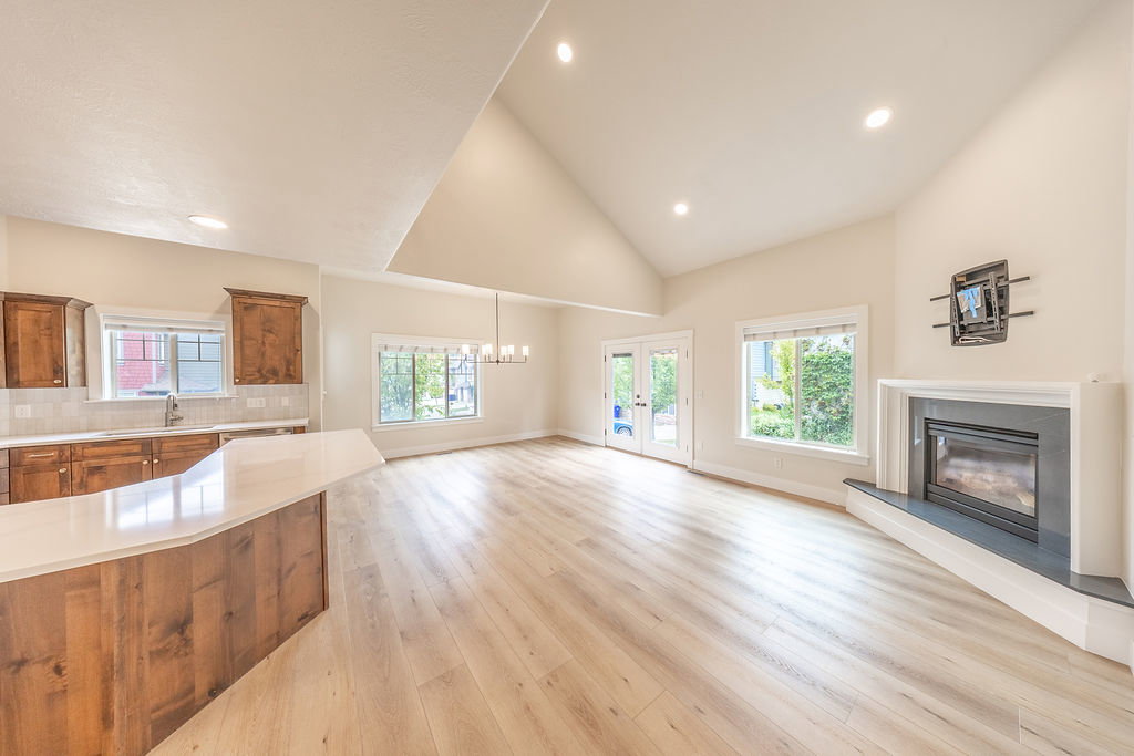 Open-concept living area with vaulted ceilings and wood-finish flooring
