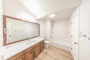 Spacious bathroom featuring a single vanity with wood cabinetry, white countertop, and a large framed mirror