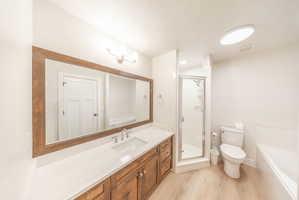 Bathroom featuring a wood-finish vanity with a light-colored countertop, an undermount sink, and a large framed mirror