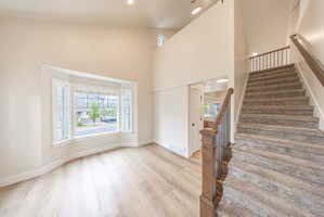 Two-story foyer featuring a carpeted staircase with wood newel posts and metal balusters