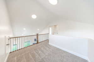 Spacious loft area featuring sloped ceilings, recessed and flush-mount lighting, and carpet flooring