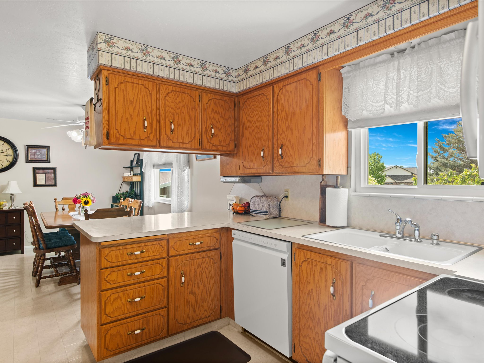 Kitchen featuring wood cabinetry, light countertops, and a white sink with a chrome faucet
