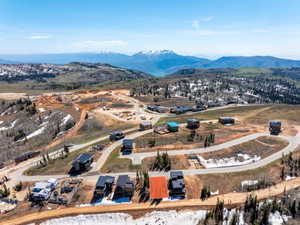 Aerial overview of a mountain community featuring multiple residential properties and building sites