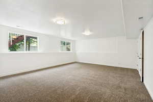 Spacious room featuring neutral carpeting and white painted walls