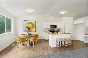 Open-concept kitchen and dining area featuring wood-finish flooring