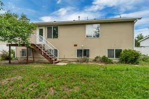 Rear exterior of the property featuring a walk-out deck with stairs to the yard