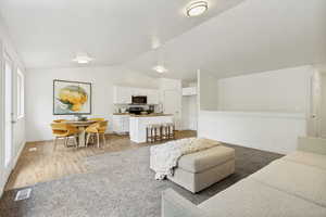 Open-concept living space featuring a kitchen, dining area, and living room