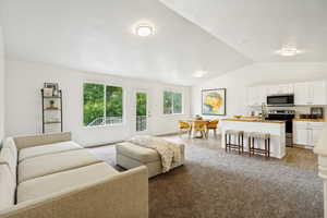 Open concept living area with vaulted ceilings and recessed lighting