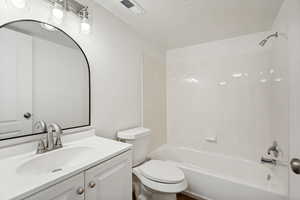 Bathroom featuring a white vanity with an integrated sink, brushed nickel faucet, and overhead bar light fixture