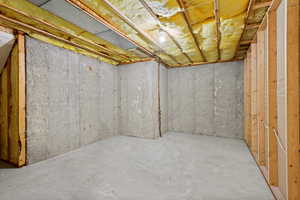 Unfinished basement space with concrete flooring and exposed concrete walls