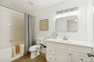 Bathroom featuring a white vanity with paneling and storage, a white countertop, and a rectangular undermount sink
