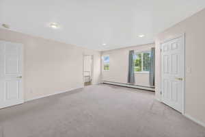 Primary Bedroom.  Spacious room featuring light gray carpet flooring, recessed ceiling lighting, and two windows providing natural illumination