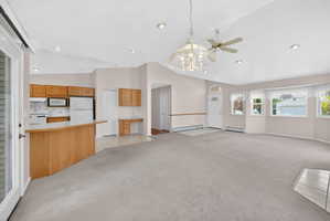 Open-concept living area featuring vaulted ceilings with recessed lighting and a ceiling fan