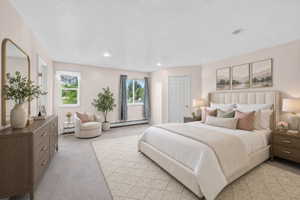 Virtual staging included to showcase room potential.  Primary Spacious bedroom featuring light-colored walls, recessed ceiling lighting, and two windows