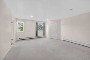 Priamary Bedroom. Spacious room featuring light-colored carpeting, recessed lighting, and two windows with white trim
