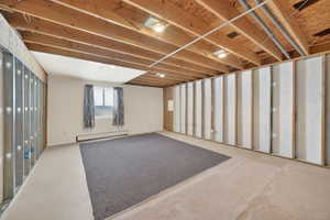 Unfinished basement space featuring exposed wood joists and structural beams