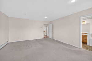 Primary Bedroom.  Spacious room featuring neutral carpeting, light-toned walls, and recessed lighting