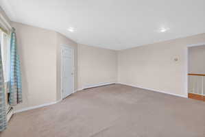 Primary Bedroom.  Carpeted room with neutral wall tones and recessed lighting