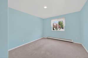 Carpeted room featuring light blue walls, white trim, a single window, and a ceiling-mounted light fixture
