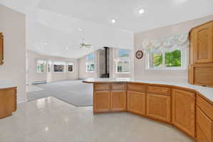 Kitchen featuring wood cabinetry, light-toned countertops, and a window above the sink