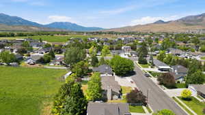 Expansive residential area featuring established homes, mature landscaping, paved streets, and mountainous terrain in the distance