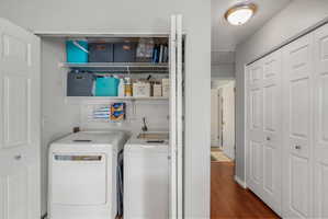 Dedicated laundry closet featuring a built-in top shelf, a wire rack, and bi-fold doors