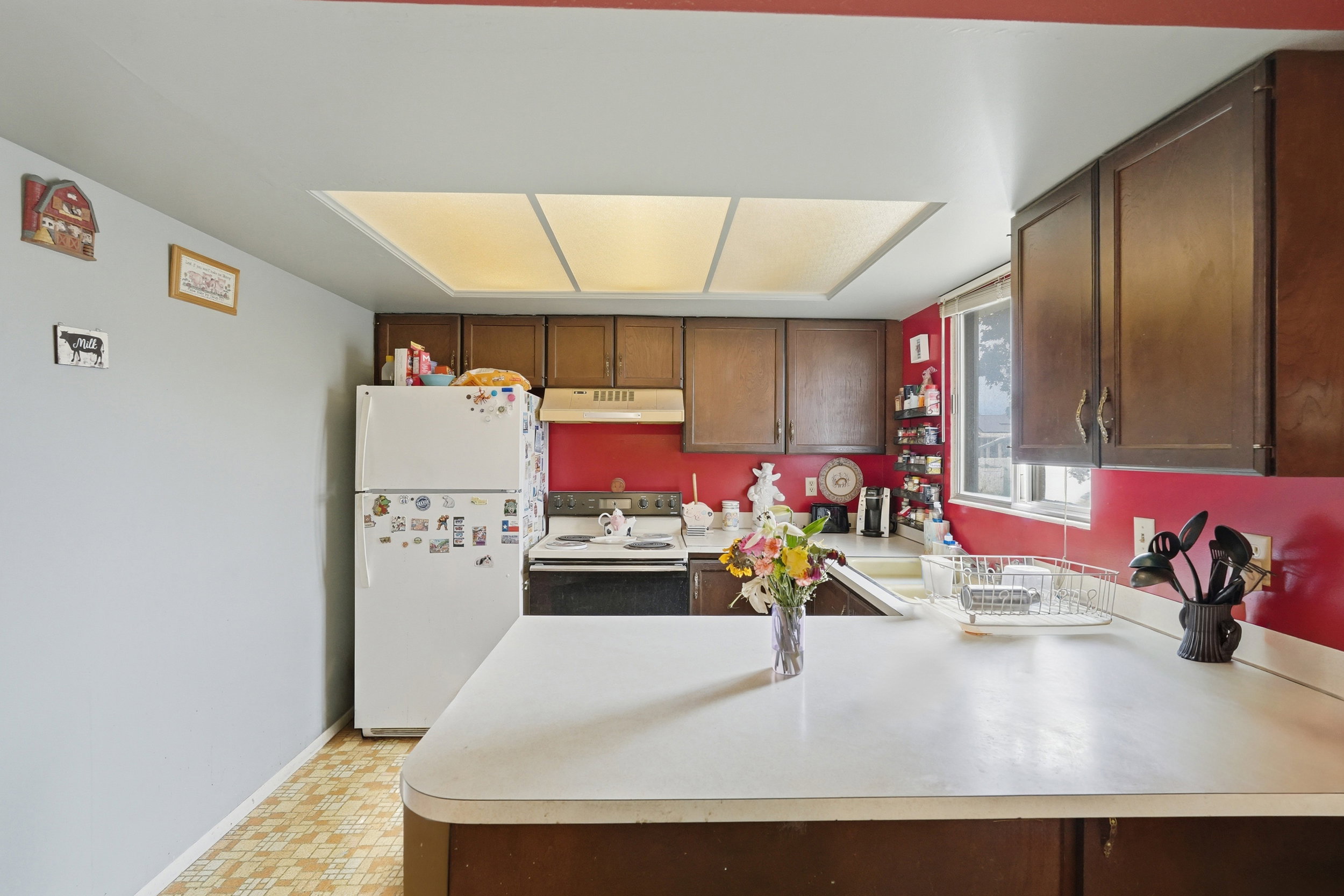 Kitchen featuring wood-finish cabinetry, solid surface countertops, and a window with exterior visibility