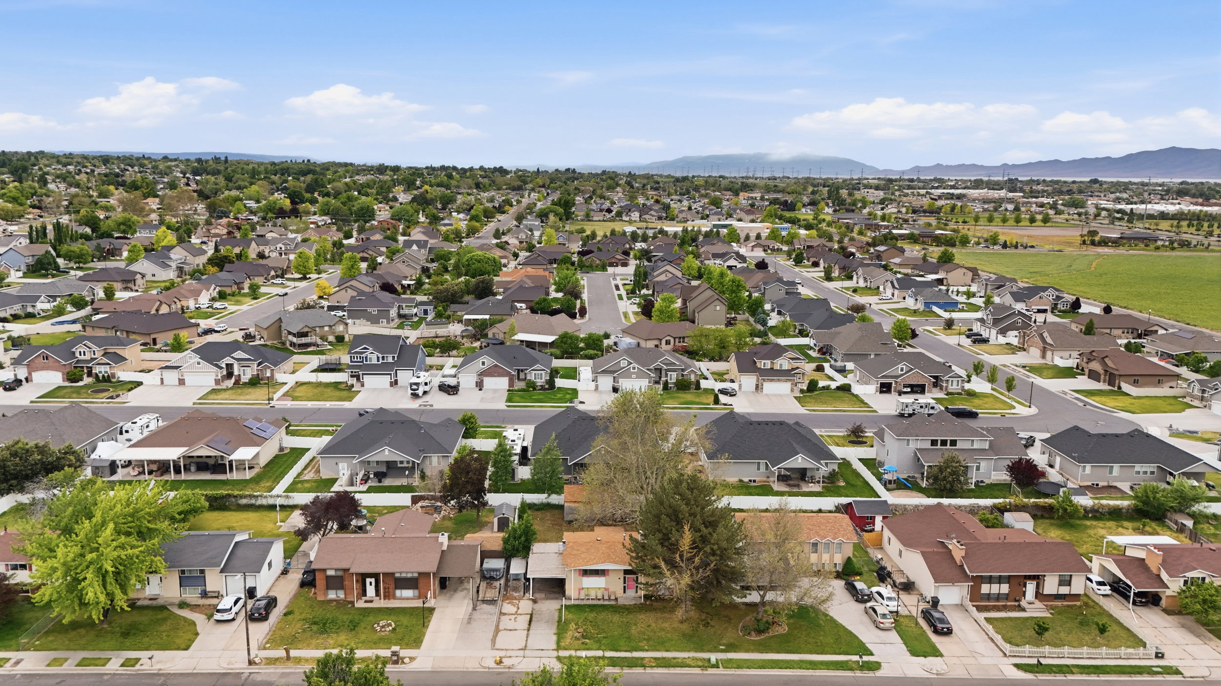 Expansive residential neighborhood featuring a variety of single-story and two-story homes with attached garages, mature landscaping, and paved streets