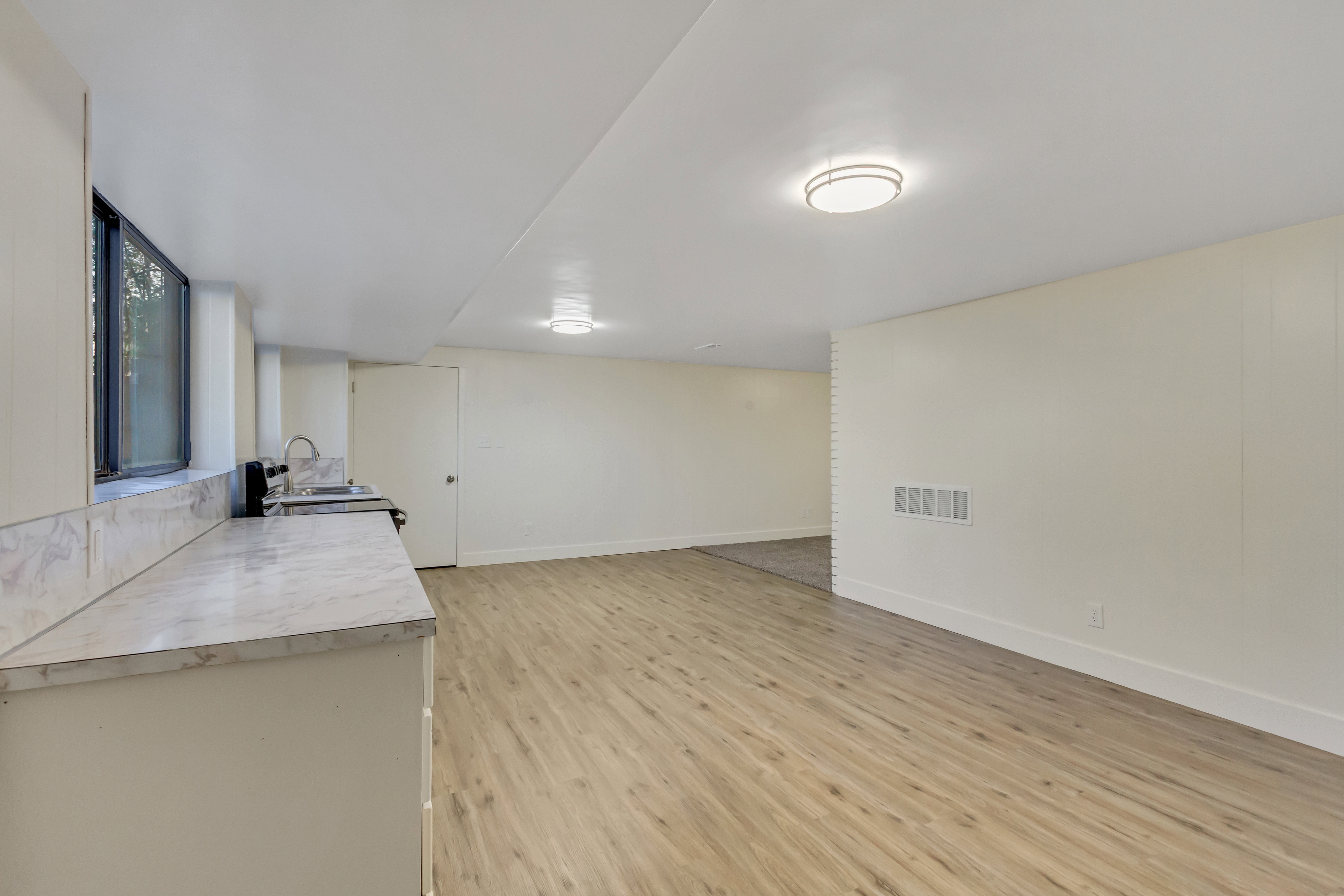 Spacious room featuring light wood-finish flooring