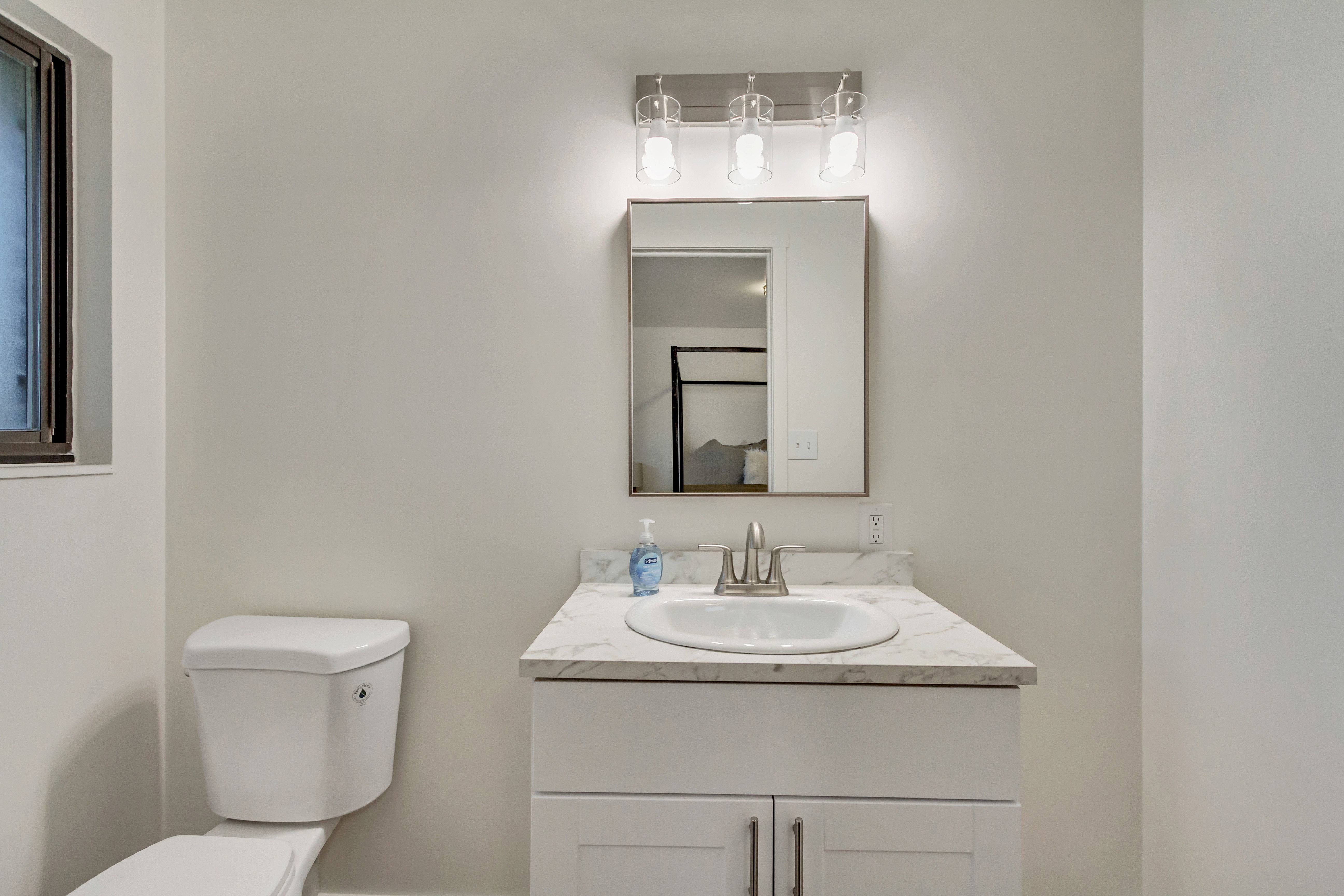 Bathroom vanity featuring a white cabinet, integrated sink, and a marbled countertop