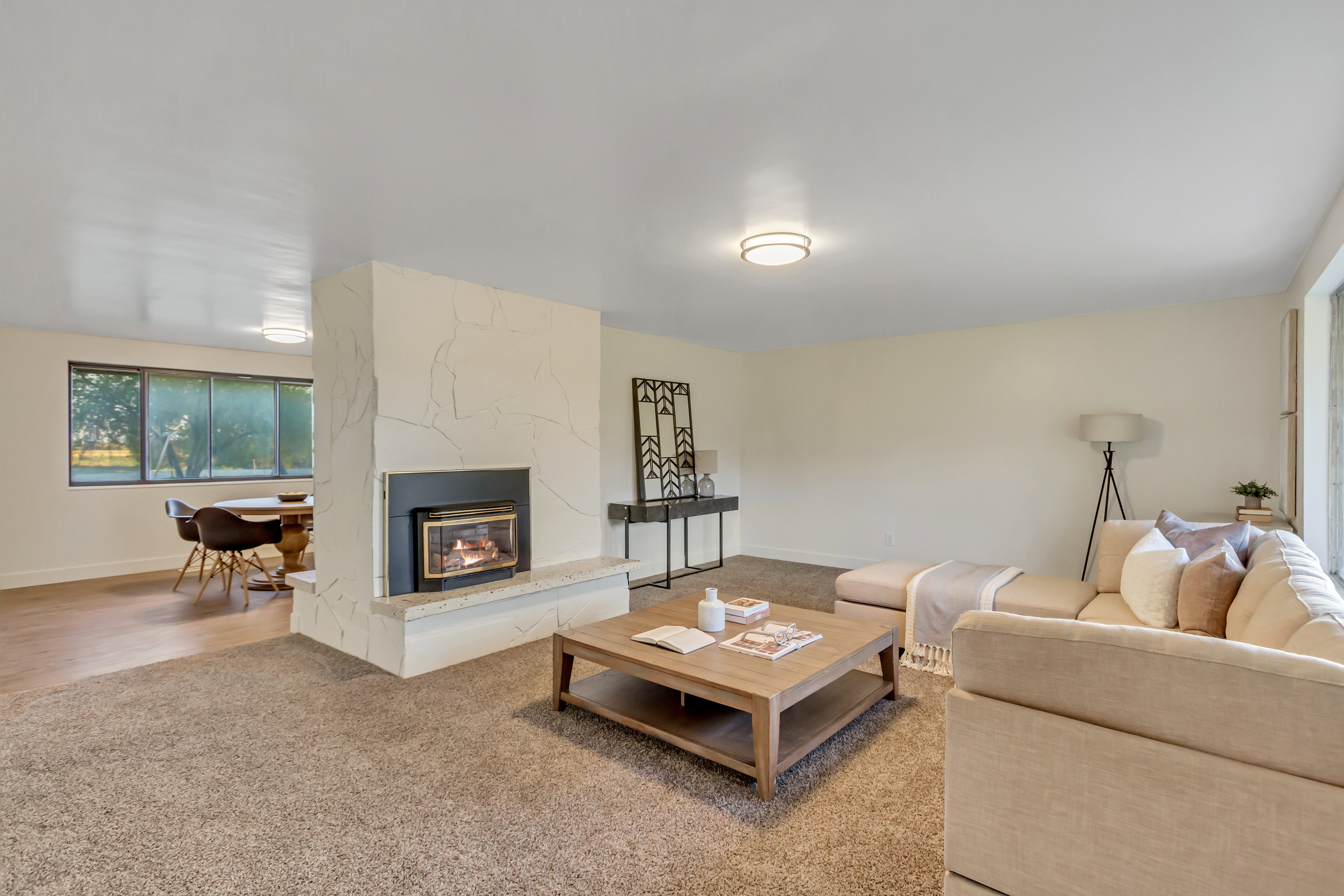 Living space featuring a central fireplace with a stone surround and hearth