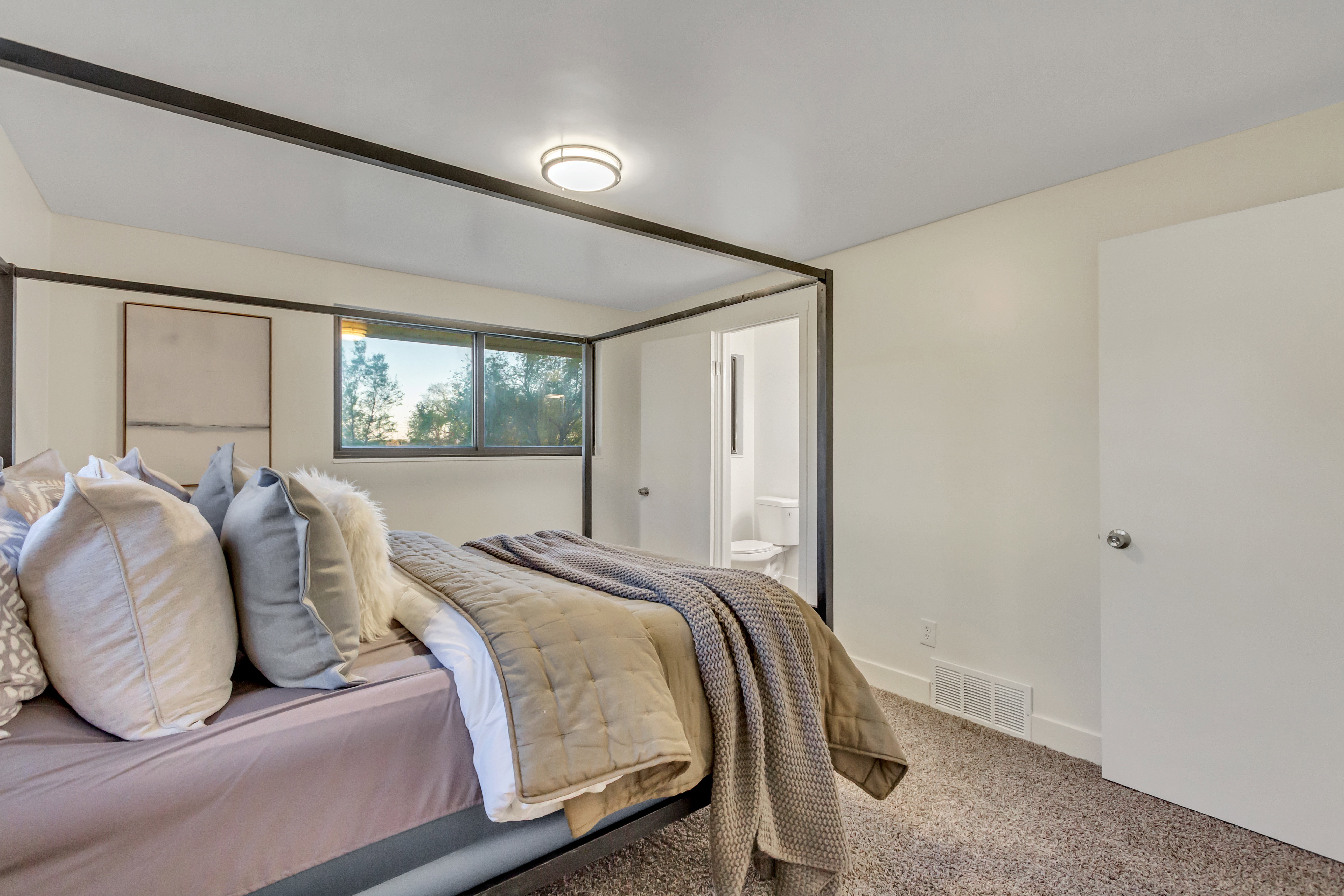 Bedroom featuring a single window, white walls, and dark carpeting