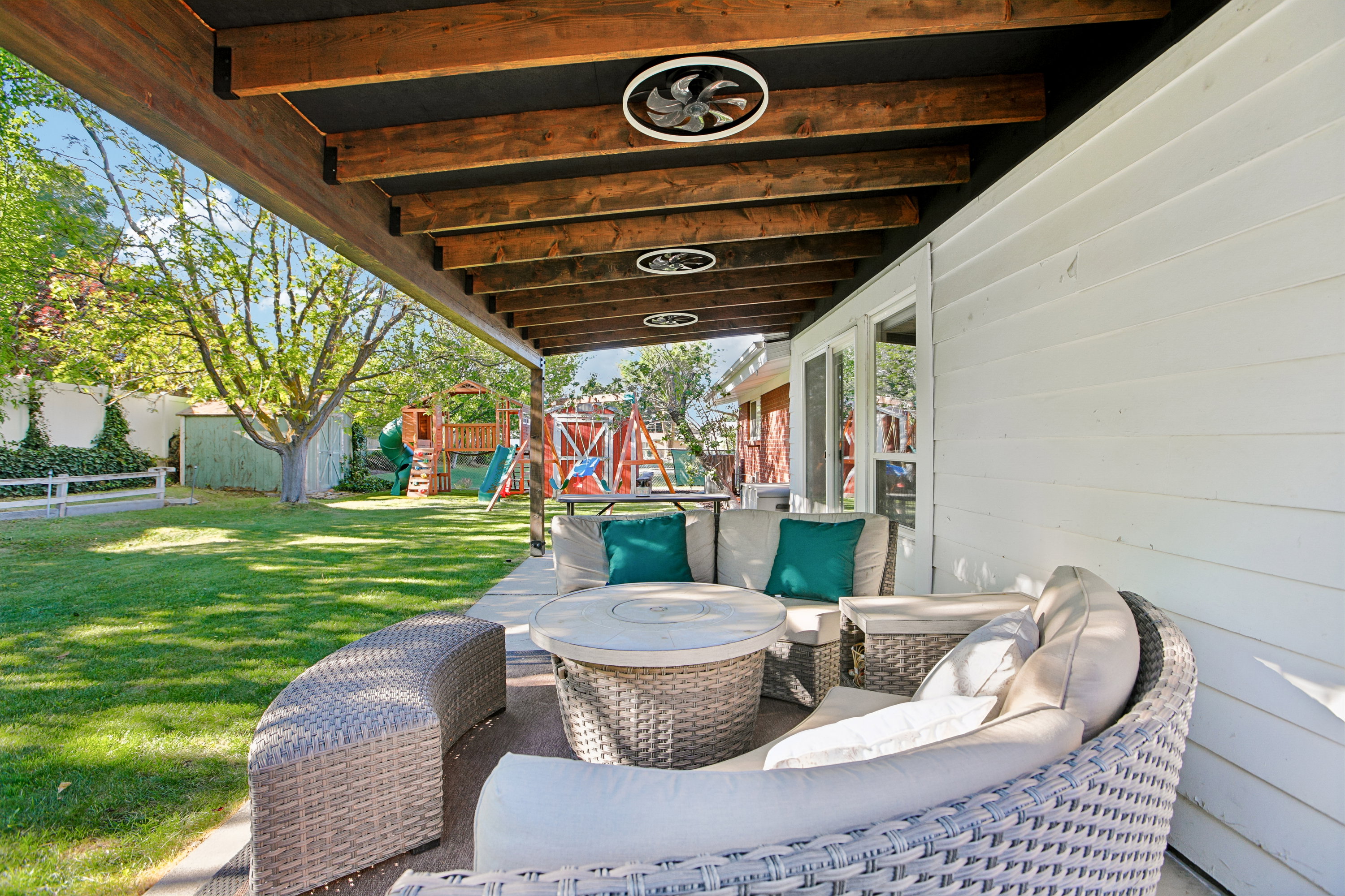 Covered patio featuring exposed wood beams, recessed lighting, and ceiling fans