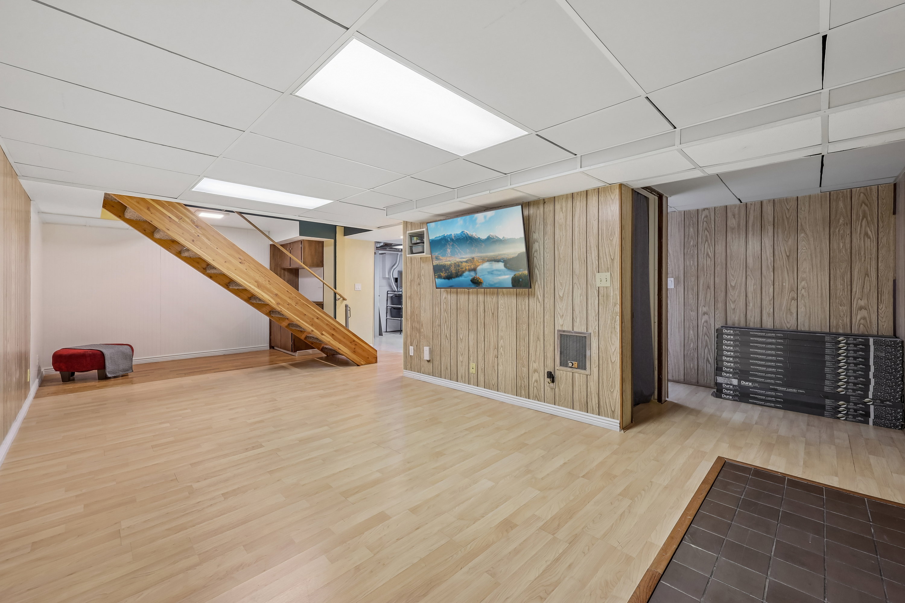 Spacious lower level featuring wood-finish flooring, a contemporary wooden staircase, and recessed lighting