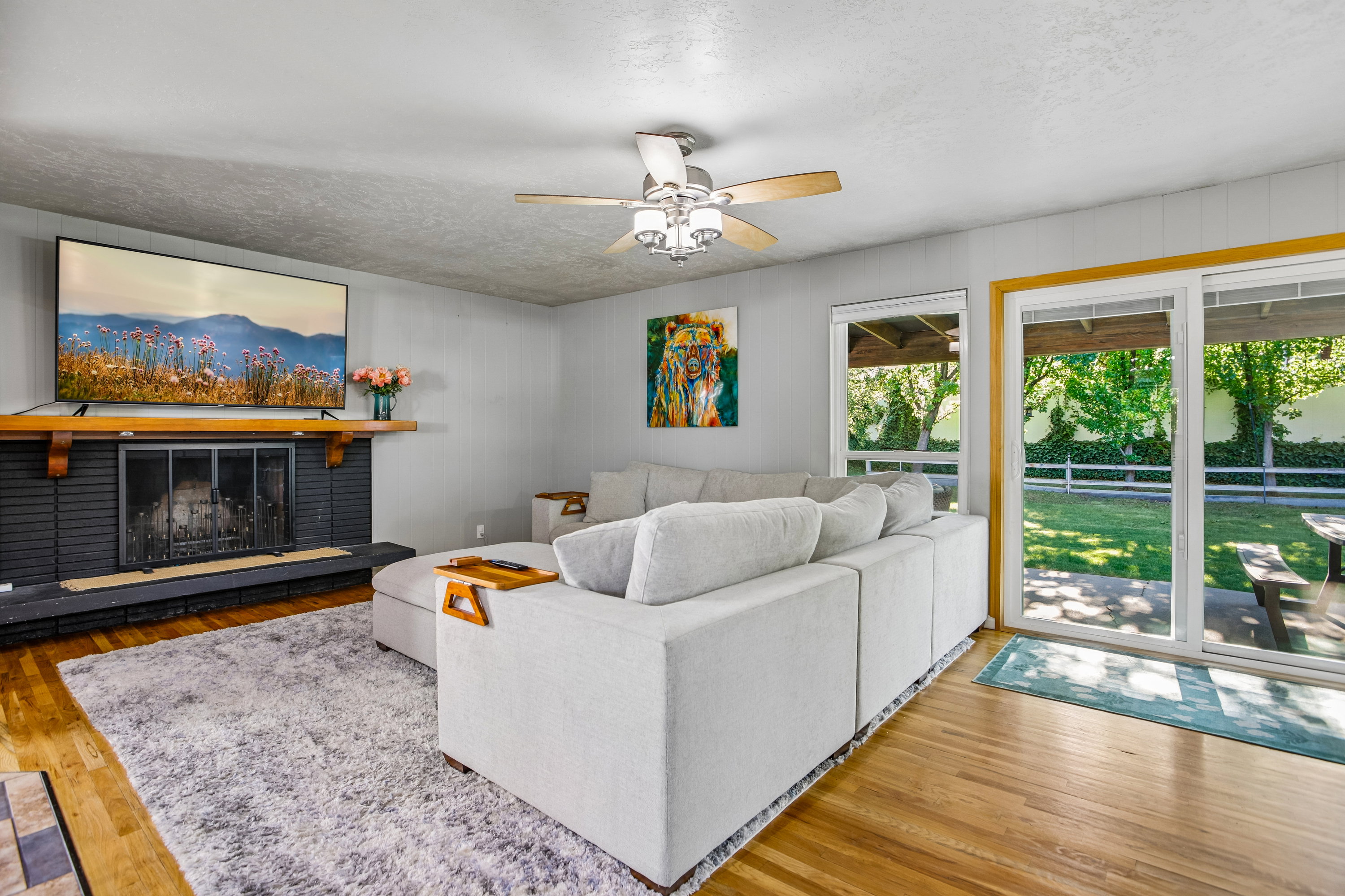 Living area featuring a fireplace with a black brick surround and a wood mantel