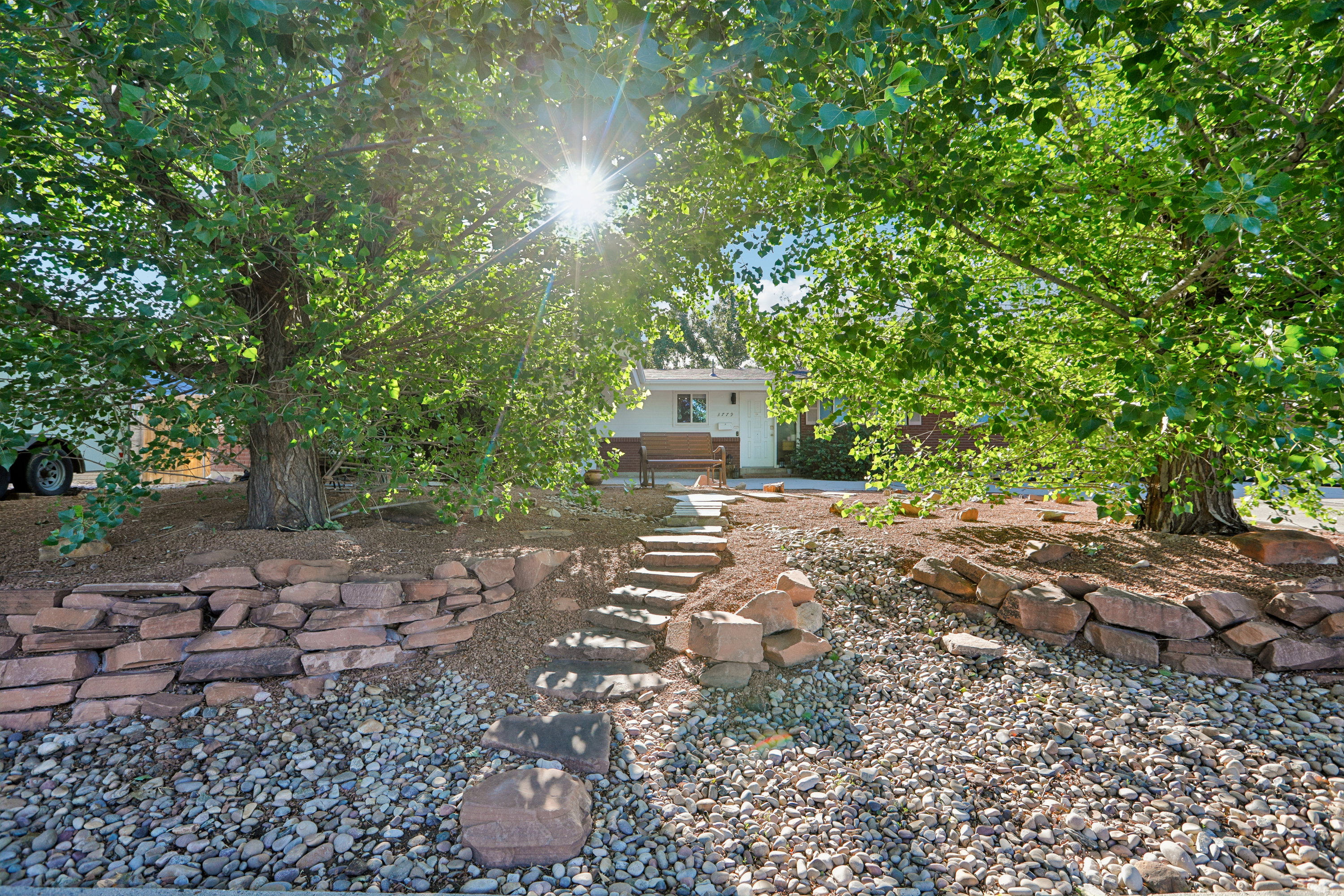 Terraced front yard with stone retaining walls and pebble landscaping