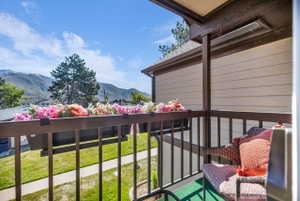 Balcony featuring a dark brown metal railing, a built-in overhead heater, and a mountain backdrop