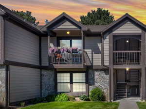 Multi-level exterior featuring stone veneer accents, horizontal siding, and multiple balconies