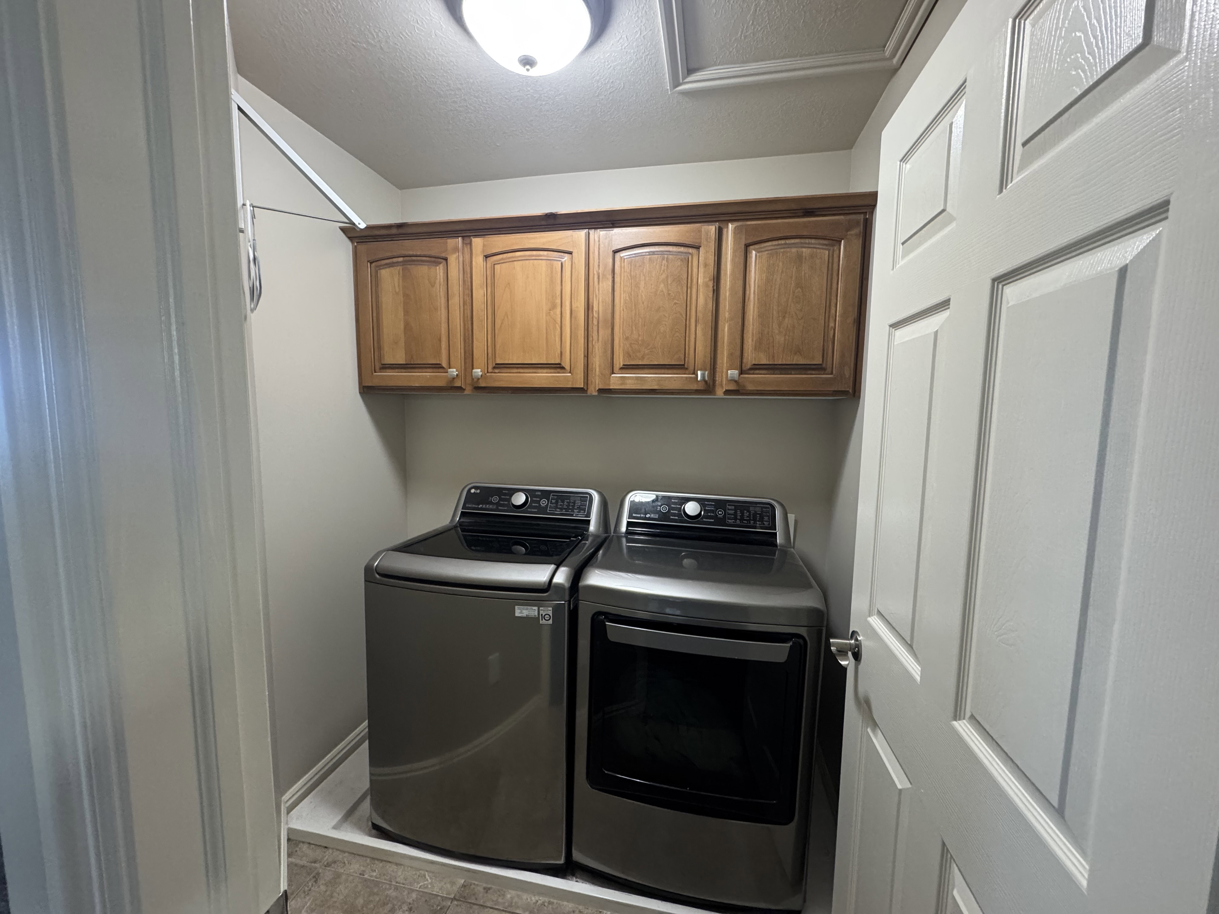 Dedicated laundry space featuring wood cabinetry