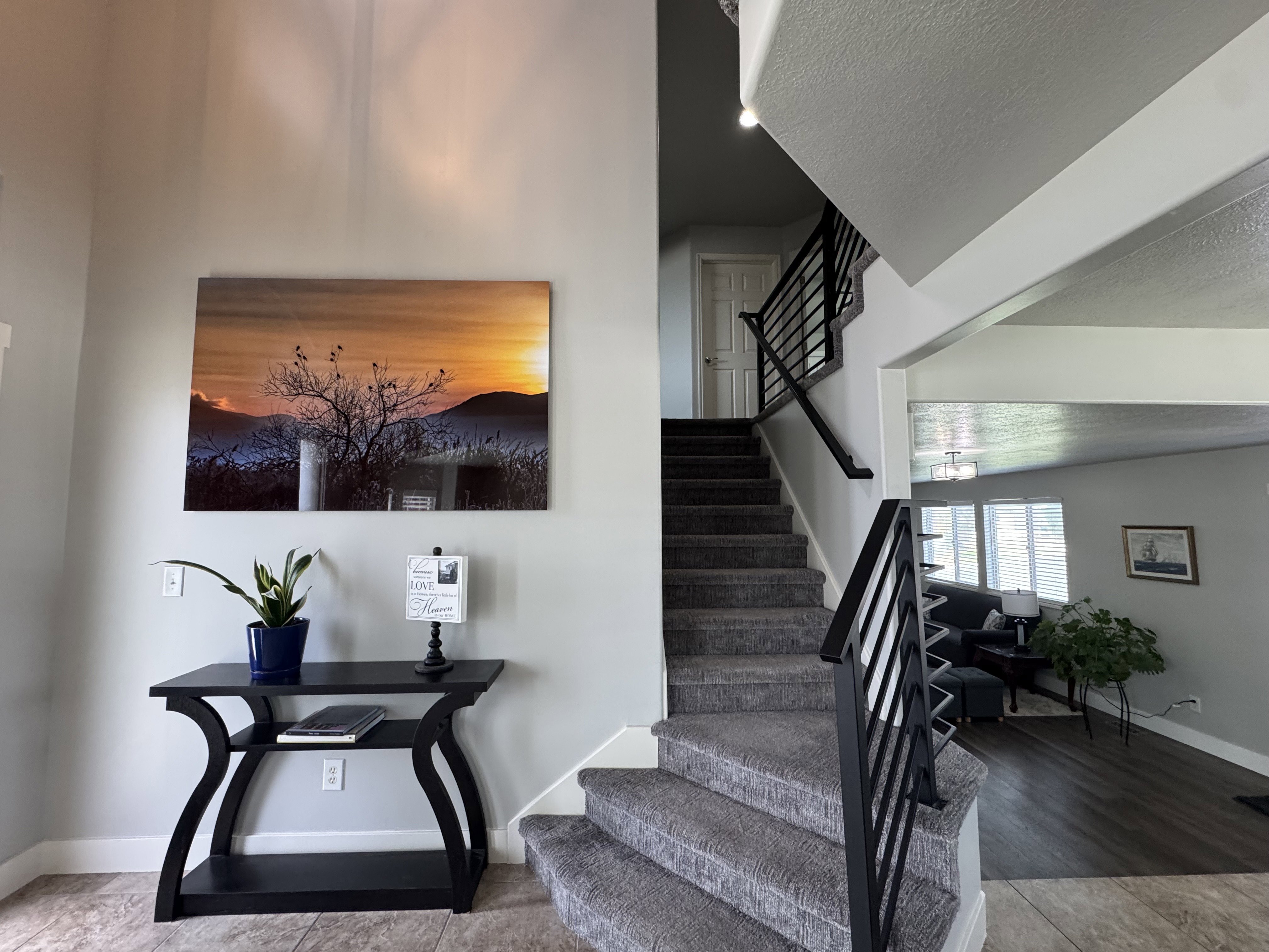 Carpeted staircase with contemporary metal railings and a high ceiling