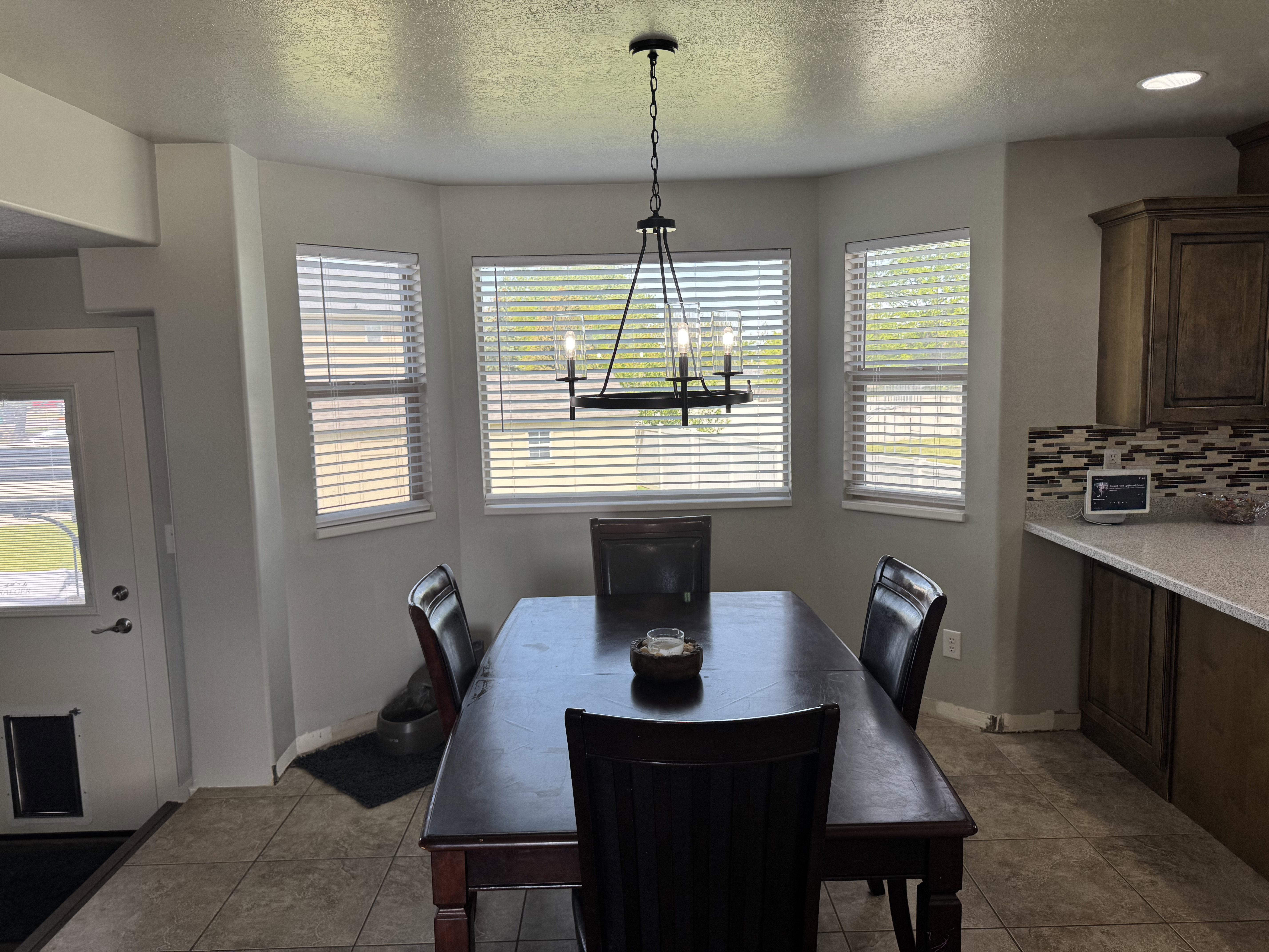 Dining area featuring a bay window with multiple windows, a wrought iron chandelier, and tile flooring